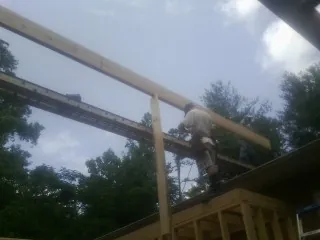 Carpenter setting a ridge beam over a new addition frame — Ice Dam Removal by Roofing Brothers in Mount Croghan