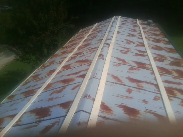 Rusted metal roof panels with new wood purlins before replacement — Storm Damage Roof Repair in Mount Croghan by Roofing Brothers