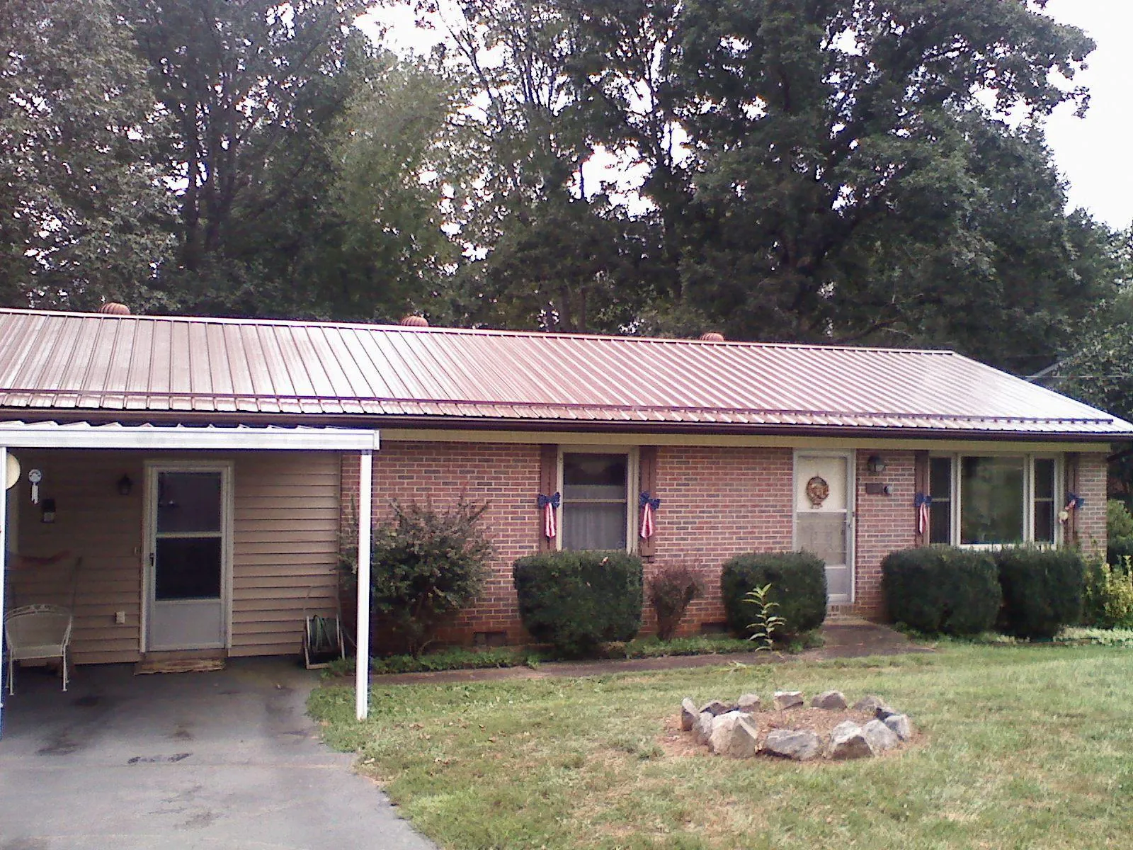 Bronze metal roof and carport on a brick ranch home — Roof Repair work by our crew in Mount Croghan